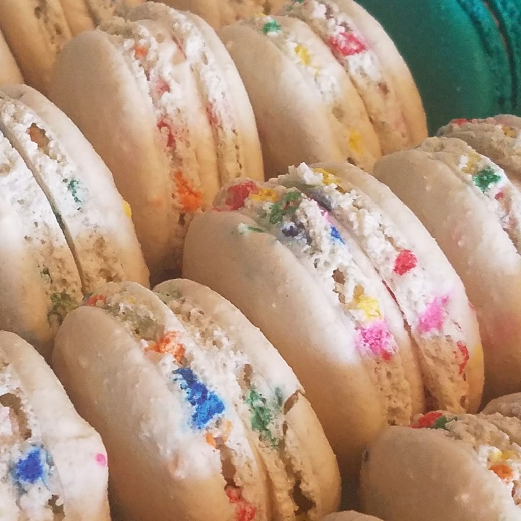 Close-up of vanilla macarons filled with rainbow sprinkles