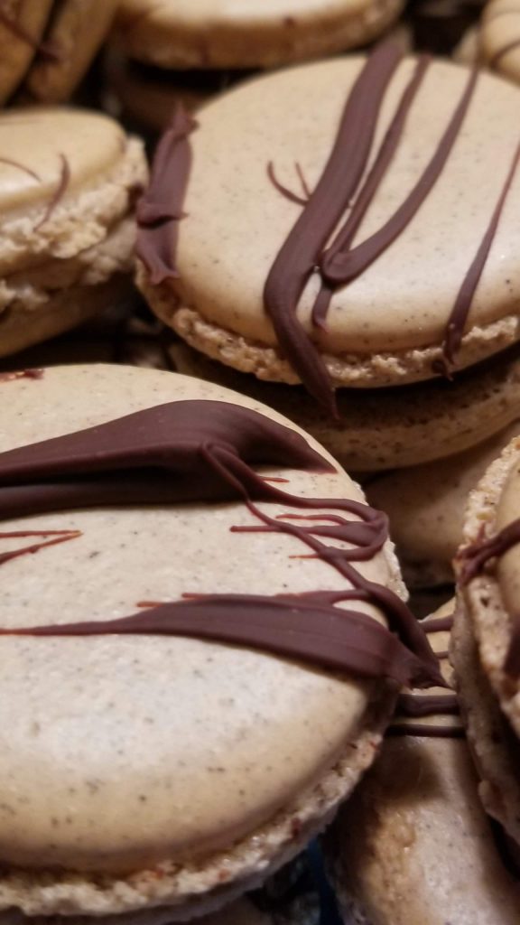 Macarons finished with a dark chocolate drizzle