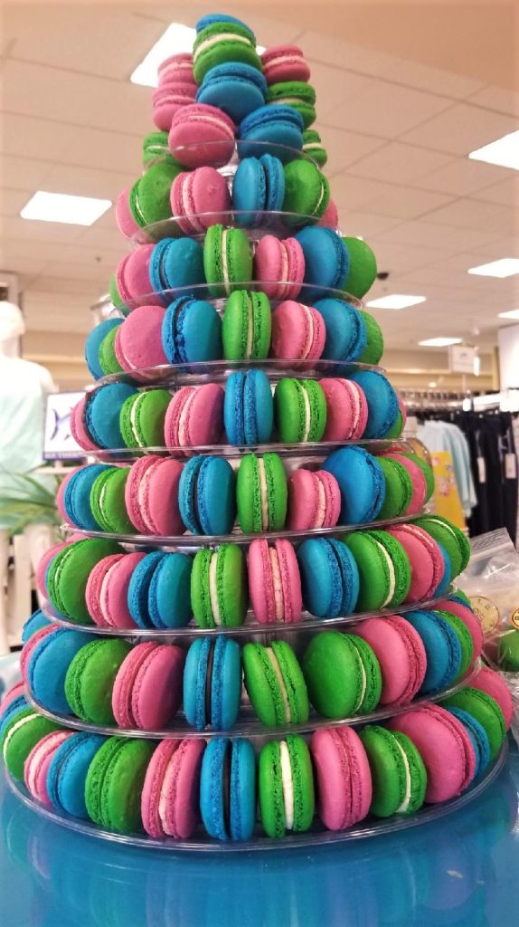A tall rainbow macaron tower in pink, green and blue for a celebration