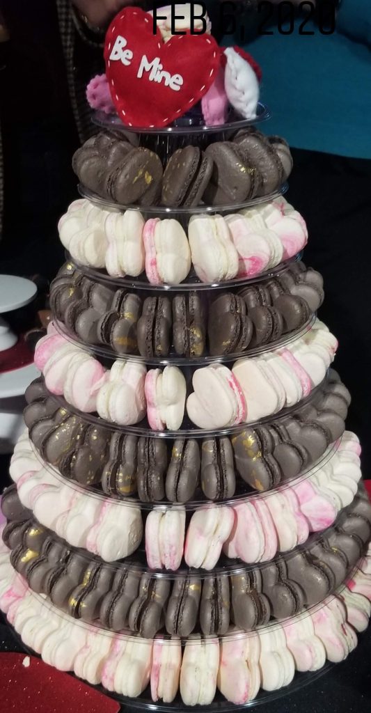 A Valentine's Day macaron tower in chocolate and pink with a Be Mine heart on top