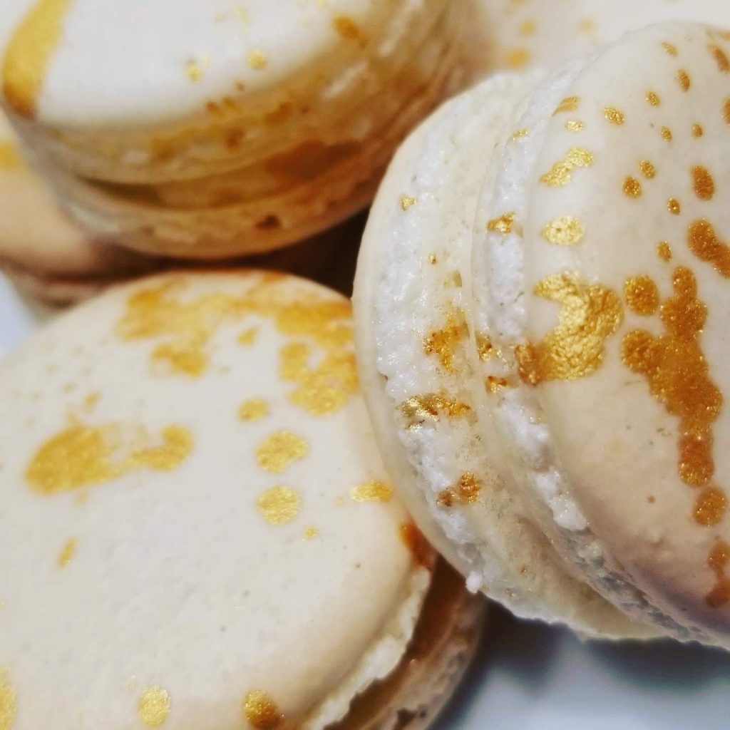 Close-up of vanilla macarons decorated with a gold splash