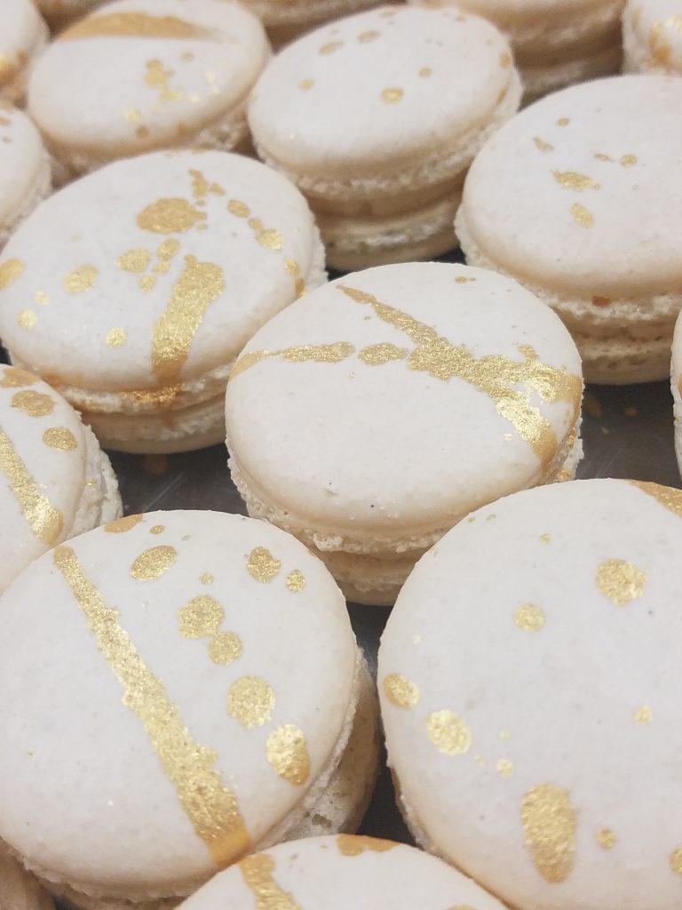 White macarons decorated with brushed gold